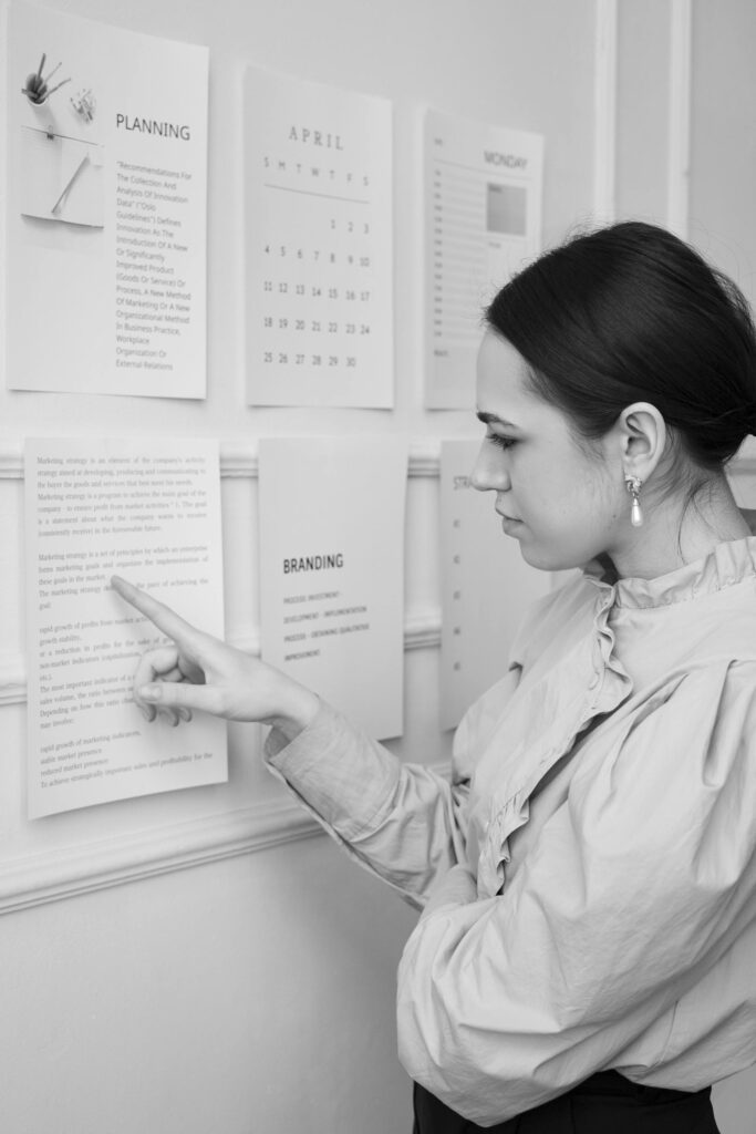 Woman looking at marketing strategy document posted on a wall