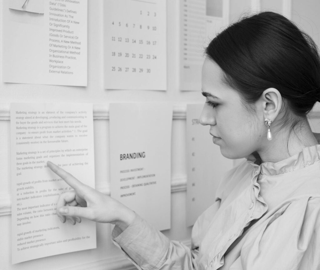 Woman looking at marketing strategy document posted on a wall